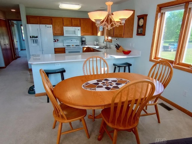 1750 Castleview Ct, Gladwin, MI 48624 - kitchen with white appliances, a sink, brown cabinets, light countertops, and healthy amount of natural light
