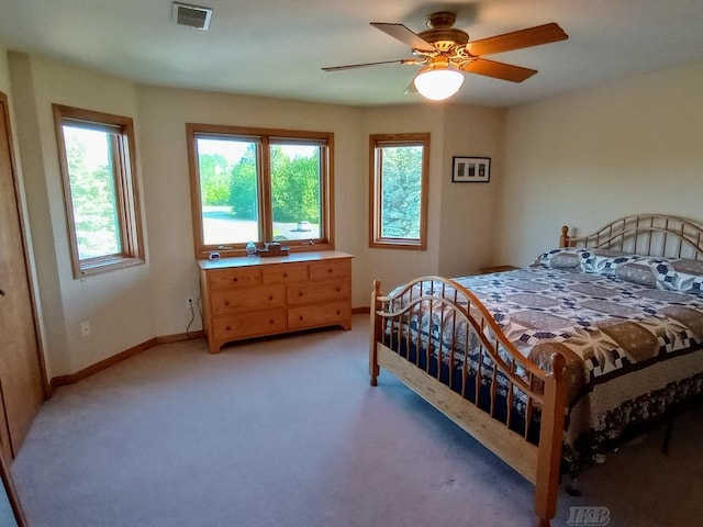 1750 Castleview Ct, Gladwin, MI 48624 - bedroom featuring multiple windows, light carpet, baseboards, and a ceiling fan