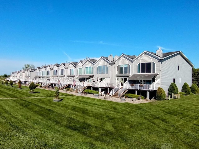 1750 Castleview Ct, Gladwin, MI 48624 - back of house with a lawn, a chimney, and stairway