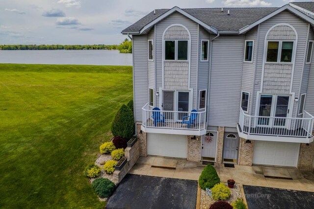 1750 Castleview Ct, Gladwin, MI 48624 - view of front facade featuring a water view, a front yard, asphalt driveway, and an attached garage