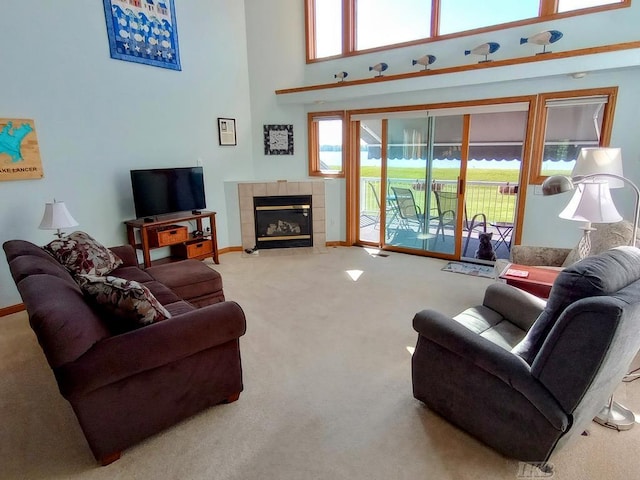 1750 Castleview Ct, Gladwin, MI 48624 - carpeted living room featuring a high ceiling, a fireplace, and baseboards