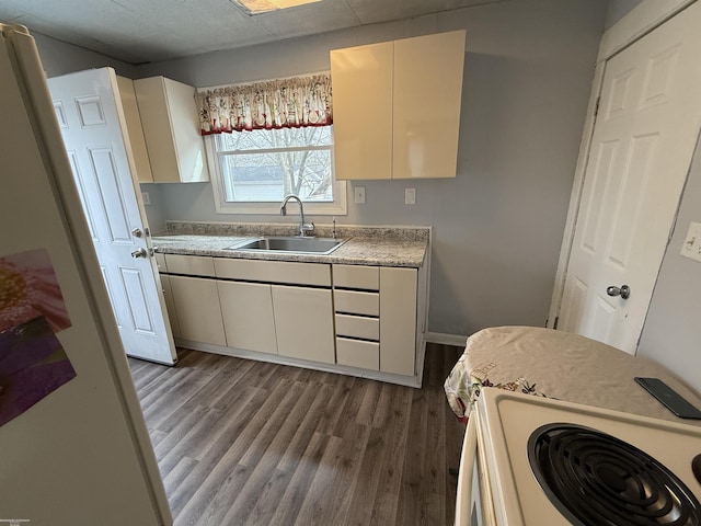 1009 May St, Lansing, MI 48906 - kitchen featuring a sink, electric range, wood finished floors, light countertops, and baseboards