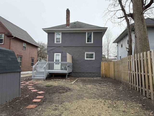 1009 May St, Lansing, MI 48906 - rear view of property featuring a deck, a chimney, and stucco siding
