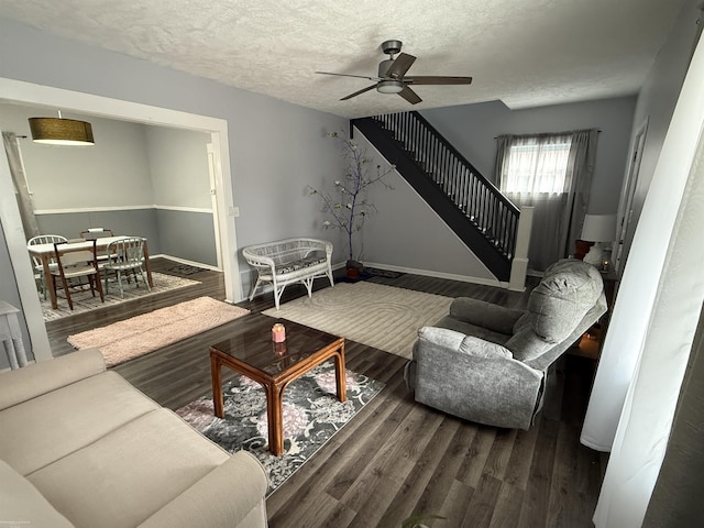 1009 May St, Lansing, MI 48906 - living room with stairs, a ceiling fan, wood finished floors, a textured ceiling, and baseboards