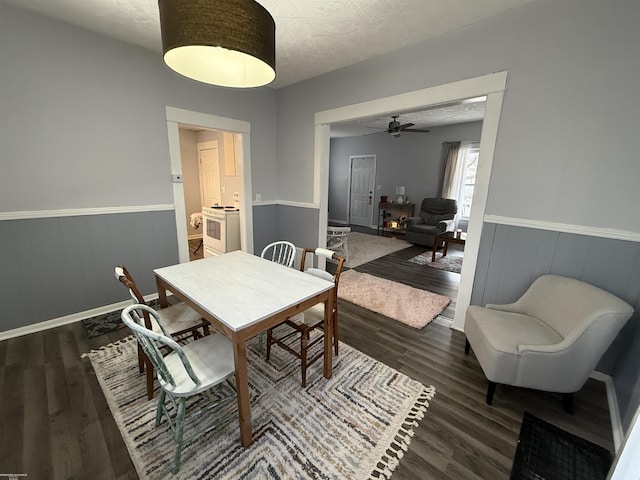 1009 May St, Lansing, MI 48906 - dining area featuring a wainscoted wall, dark wood-style flooring, a ceiling fan, a textured ceiling, and baseboards