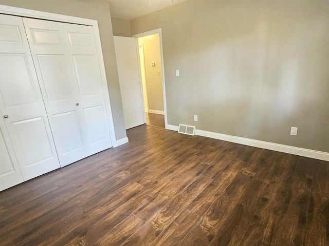 3045 W Birch Dr, Bay City, MI 48706 - unfurnished bedroom featuring dark wood-type flooring, baseboards, and a closet