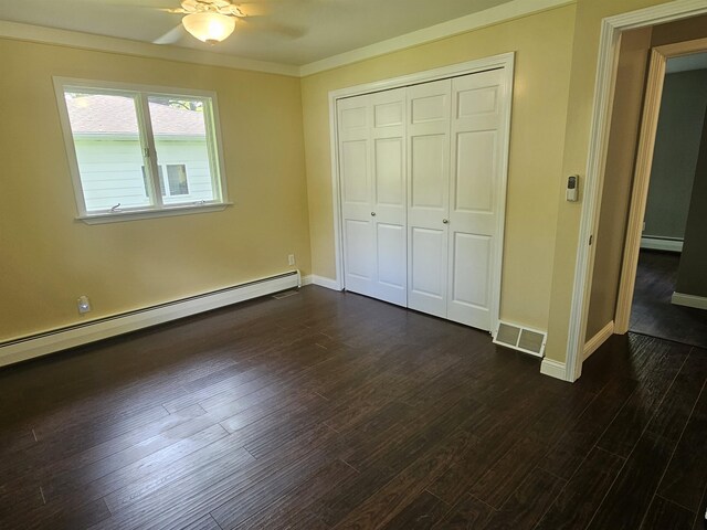 3045 W Birch Dr, Bay City, MI 48706 - unfurnished bedroom with a baseboard radiator, dark wood-style flooring, a closet, baseboards, and crown molding
