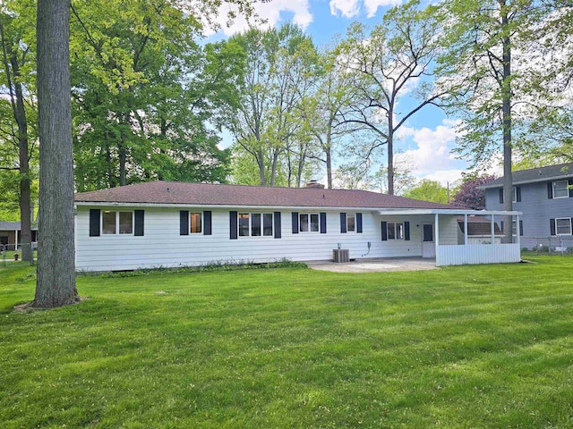 3045 W Birch Dr, Bay City, MI 48706 - back of property featuring a patio, central AC, a yard, and a chimney