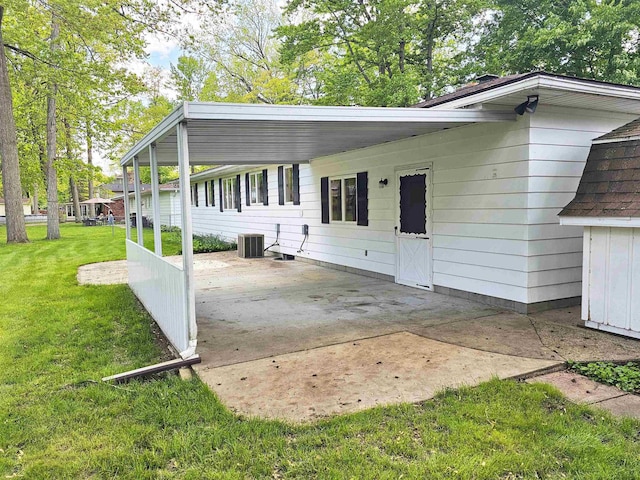 3045 W Birch Dr, Bay City, MI 48706 - rear view of property with a lawn, central AC unit, and a carport