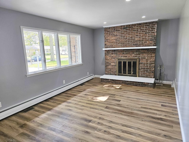3045 W Birch Dr, Bay City, MI 48706 - unfurnished living room with a baseboard radiator, wood finished floors, recessed lighting, baseboards, and a fireplace