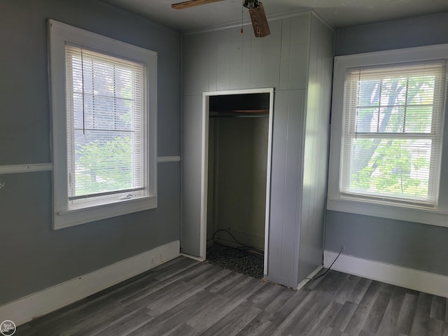 730 Jenkinson St, Port Huron, MI 48060 - unfurnished bedroom featuring dark wood-type flooring, multiple windows, a closet, baseboards, and crown molding