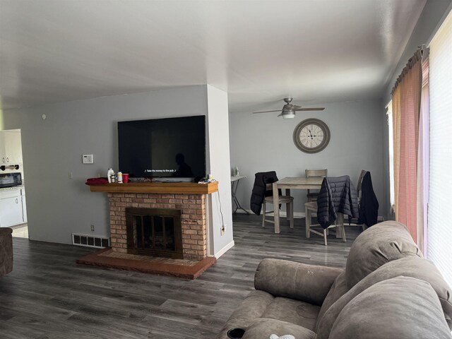 5431 Threasa St, Saginaw, MI 48603 - living area featuring wood finished floors, a ceiling fan, healthy amount of natural light, and a brick fireplace