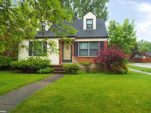 21102 Lancaster St, Harper Woods, MI 48225 - cape cod house with a front yard, brick siding, and roof with shingles