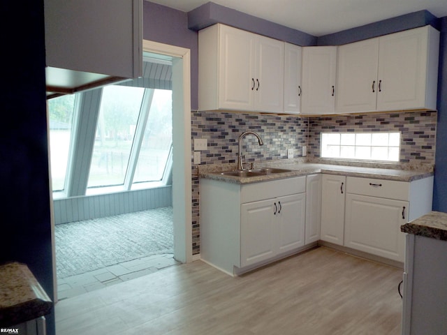 21102 Lancaster St, Harper Woods, MI 48225 - kitchen featuring a sink, white cabinetry, tasteful backsplash, and light wood-style floors