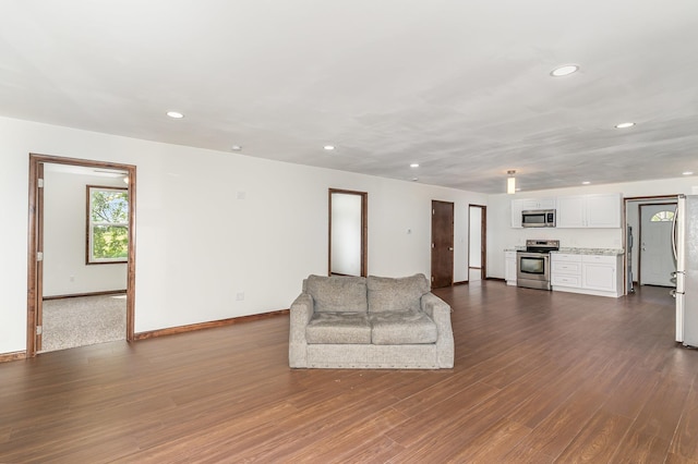 2695 Hupter Rd, Pinconning, MI 48650 - unfurnished living room with dark wood-style flooring, baseboards, and recessed lighting