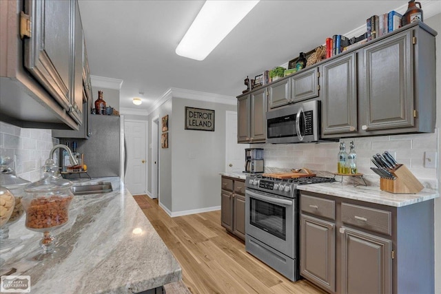 4916 Royal Cove Dr, Shelby Twp, MI 48316 - kitchen featuring stainless steel appliances, ornamental molding, tasteful backsplash, a sink, and baseboards