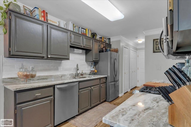 4916 Royal Cove Dr, Shelby Twp, MI 48316 - kitchen with appliances with stainless steel finishes, a sink, ornamental molding, light wood-style floors, and backsplash