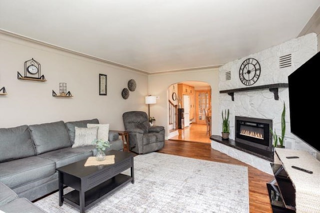 4449 S M 18 Hwy, Beaverton, MI 48612 - living room featuring arched walkways, wood finished floors, and a fireplace