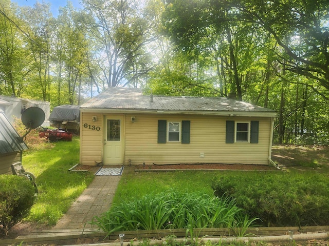 6130 Beech Dr, Lake, MI 48632 - view of front facade with metal roof and a front lawn