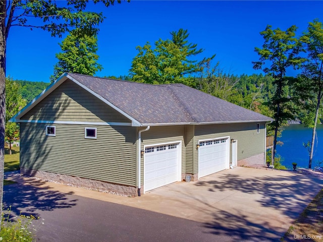 217 Shoreline Dr, Negaunee, MI 49866 - garage with concrete driveway and a water view