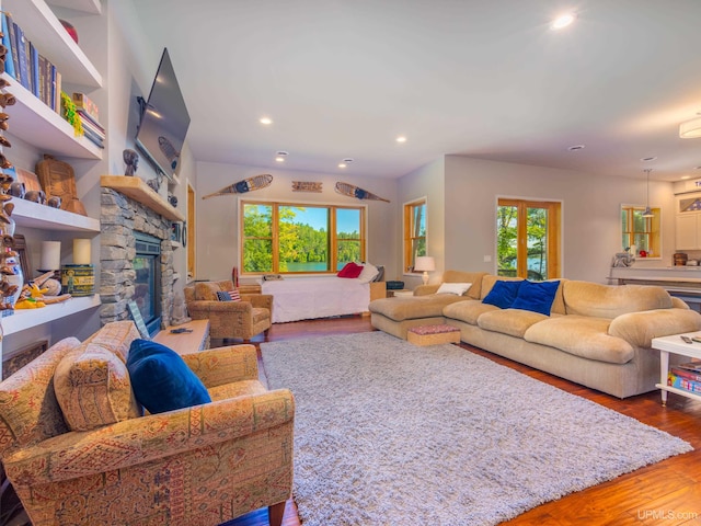217 Shoreline Dr, Negaunee, MI 49866 - living area featuring wood finished floors, a stone fireplace, and recessed lighting