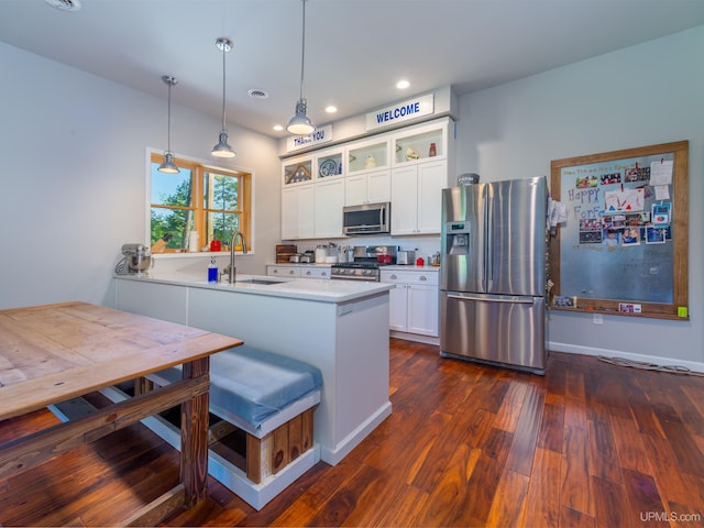 217 Shoreline Dr, Negaunee, MI 49866 - kitchen featuring appliances with stainless steel finishes, a sink, glass insert cabinets, white cabinets, and a peninsula