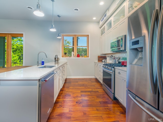 217 Shoreline Dr, Negaunee, MI 49866 - kitchen featuring stainless steel appliances, a sink, a peninsula, dark wood-style flooring, and glass insert cabinets