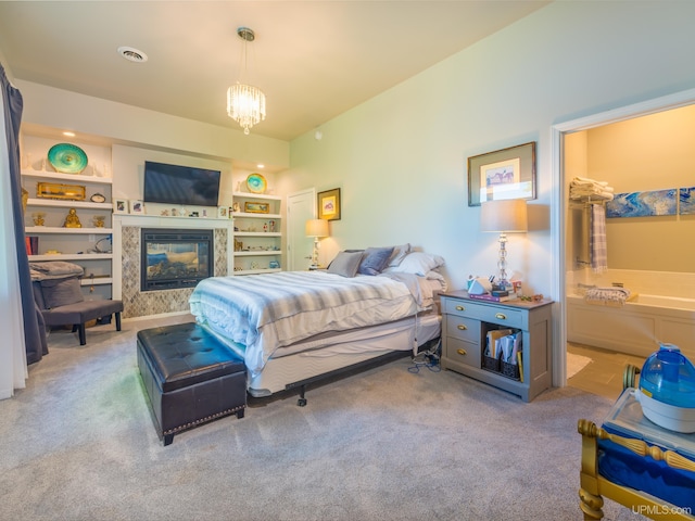 217 Shoreline Dr, Negaunee, MI 49866 - bedroom with carpet, a glass covered fireplace, and a chandelier