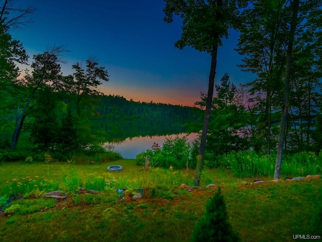 217 Shoreline Dr, Negaunee, MI 49866 - yard at dusk with a wooded view and a water view