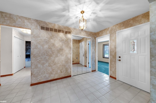 39067 Baroque Blvd, Clinton Township, MI 48038 - unfurnished room with light tile patterned flooring, a chandelier, and baseboards
