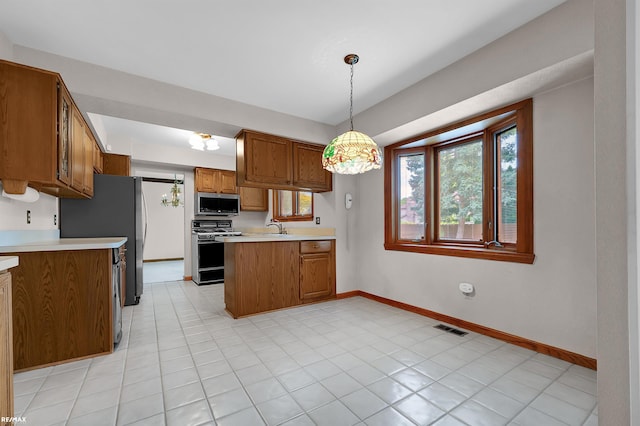39067 Baroque Blvd, Clinton Township, MI 48038 - kitchen featuring appliances with stainless steel finishes, a sink, a peninsula, brown cabinets, and light countertops