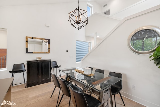 2638 John R St, Detroit, MI 48201 - dining area featuring a chandelier, light wood-style flooring, a towering ceiling, and plenty of natural light