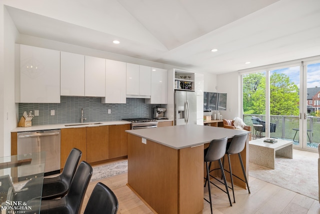 2638 John R St, Detroit, MI 48201 - kitchen featuring appliances with stainless steel finishes, a sink, light wood-style floors, vaulted ceiling, and backsplash