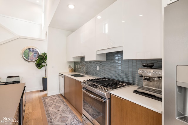 2638 John R St, Detroit, MI 48201 - kitchen featuring stainless steel appliances, a sink, light wood-style floors, backsplash, and recessed lighting