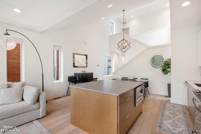 2638 John R St, Detroit, MI 48201 - kitchen featuring open floor plan, light wood-style flooring, a center island, baseboards, and high vaulted ceiling