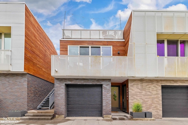 2638 John R St, Detroit, MI 48201 - contemporary house with an attached garage, a balcony, and brick siding