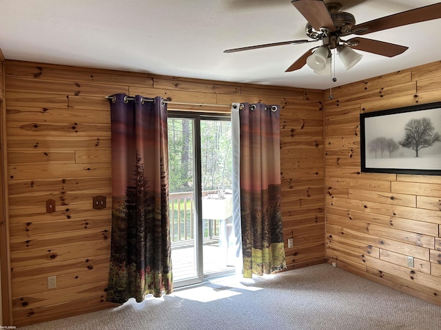 5077 Henry Hwy, Lewiston, MI 49756 - carpeted spare room featuring wood walls and a ceiling fan