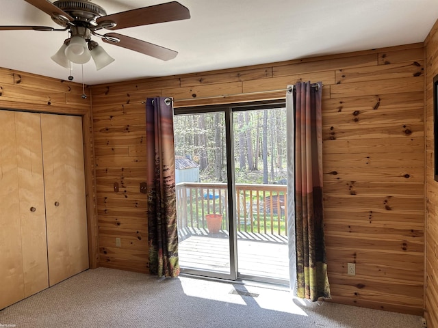 5077 Henry Hwy, Lewiston, MI 49756 - unfurnished bedroom featuring carpet, access to outside, wood walls, ceiling fan, and a closet