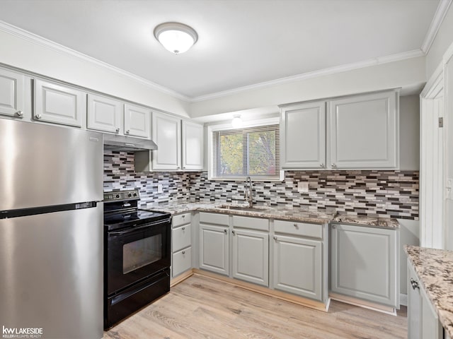 3422 S Annabelle St, Detroit, MI 48217 - kitchen with freestanding refrigerator, black electric range oven, a sink, ornamental molding, and under cabinet range hood