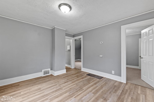 5553 Nottingham Rd, Detroit, MI 48224 - spare room featuring a textured ceiling, light wood-style flooring, ornamental molding, and baseboards