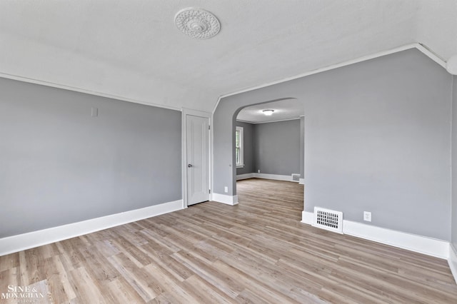 5553 Nottingham Rd, Detroit, MI 48224 - empty room with arched walkways, light wood-style floors, and baseboards