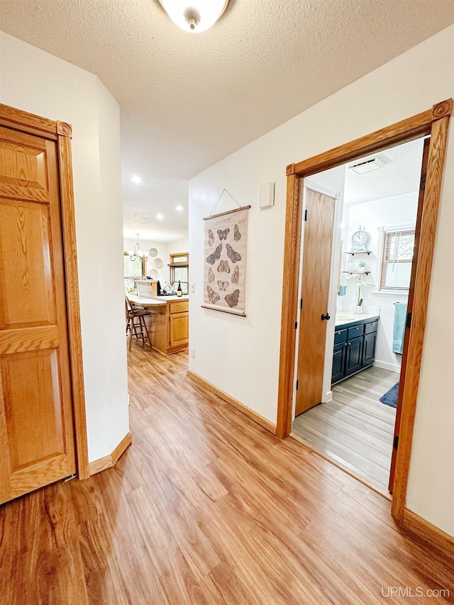 213 W Arch St, Negaunee, MI 49866 - hall with light wood-style floors, baseboards, and a chandelier