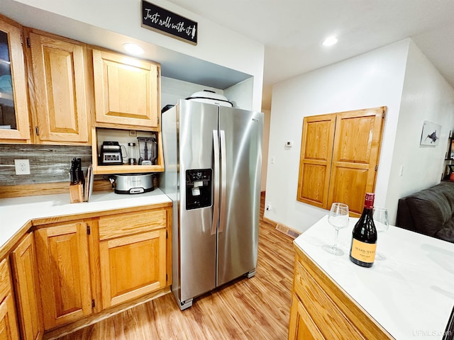 213 W Arch St, Negaunee, MI 49866 - kitchen featuring stainless steel fridge, light wood-style floors, backsplash, light countertops, and glass insert cabinets