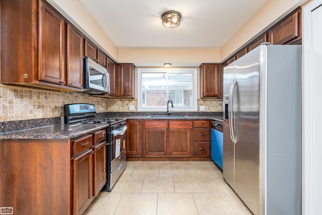 33519 Groth Ave, Sterling Heights, MI 48312 - kitchen featuring stainless steel appliances, a sink, tasteful backsplash, light tile patterned flooring, and dark stone countertops