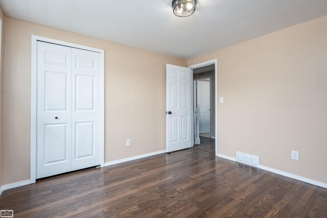 33519 Groth Ave, Sterling Heights, MI 48312 - unfurnished bedroom with dark wood finished floors, baseboards, and a closet