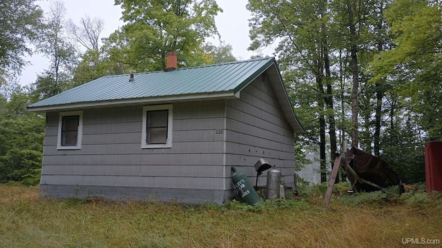 113 Paint Lake Loop, Iron River, MI 49935 - view of side of property featuring metal roof and a chimney