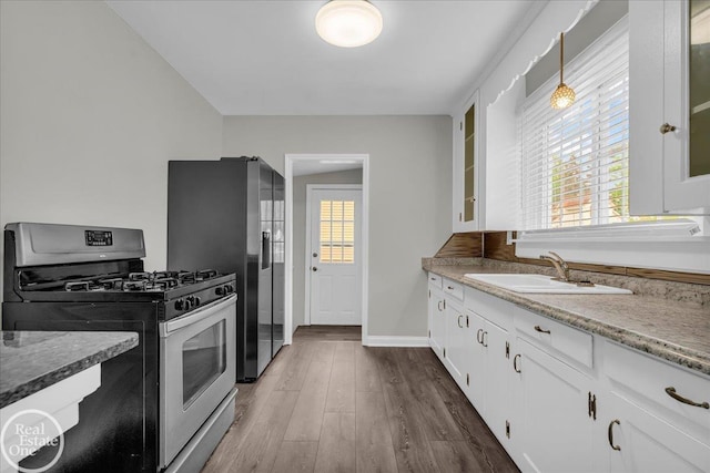 1011 Garfield St, Port Huron, MI 48060 - kitchen featuring appliances with stainless steel finishes, a sink, glass insert cabinets, white cabinetry, and dark wood-type flooring