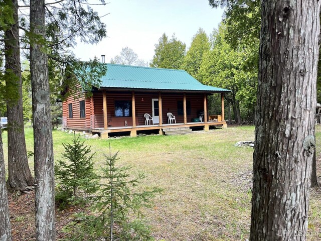 14520 7th Rd, Garden, MI 49835 - view of front of property featuring a front yard, faux log siding, and metal roof