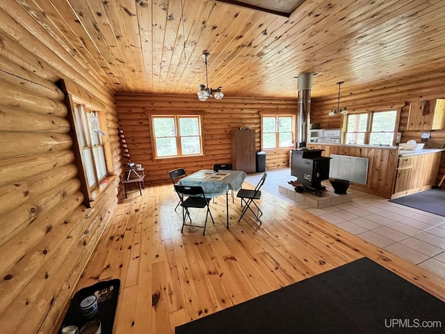 14520 7th Rd, Garden, MI 49835 - dining space with a wood stove, rustic walls, light wood-style floors, and wooden ceiling