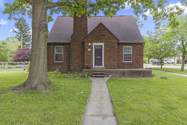 3106 Winifred St, Wayne, MI 48184 - english style home featuring a chimney, brick siding, and roof with shingles